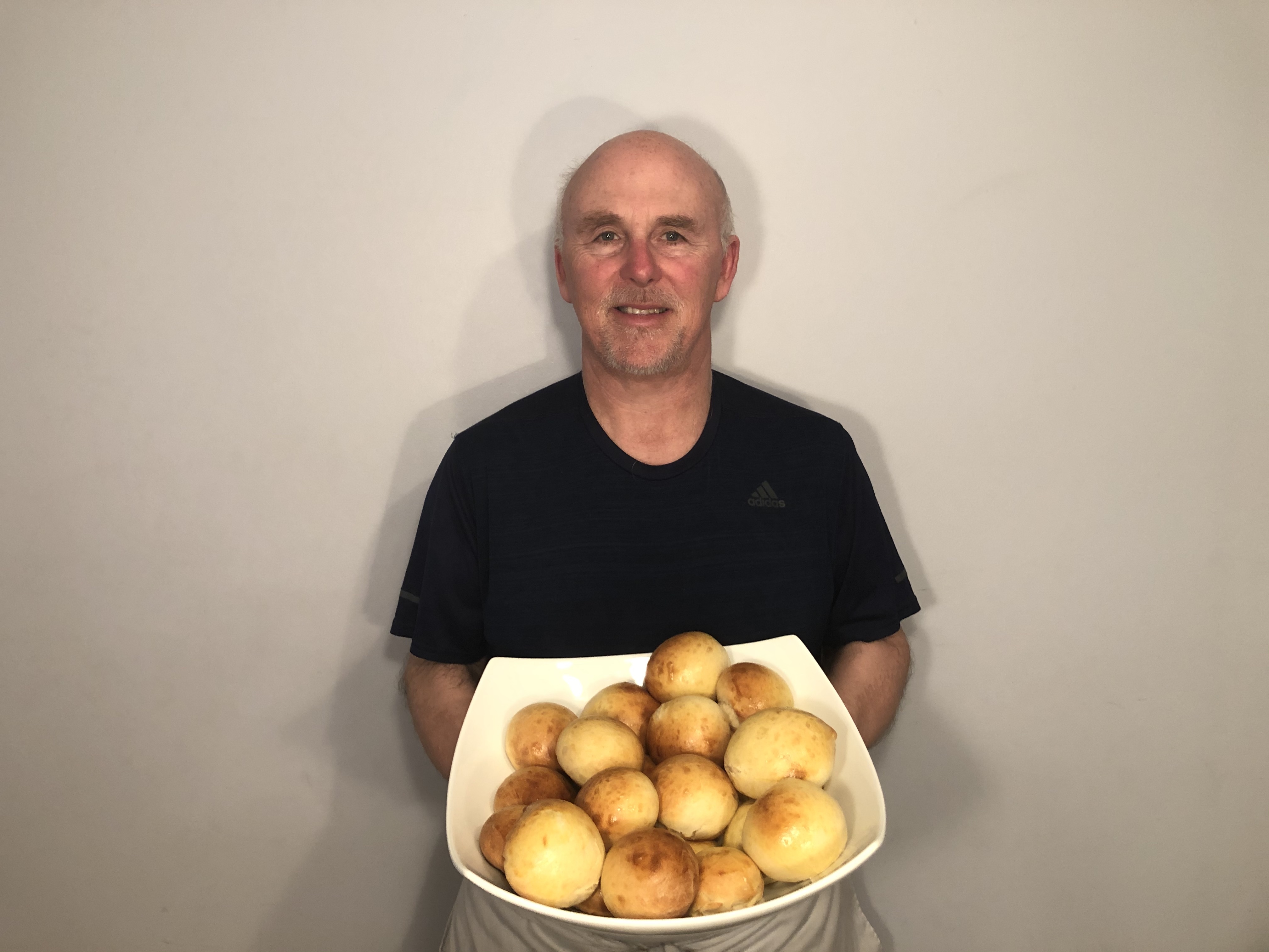 Chef Rob holding a plate of dinner rolls