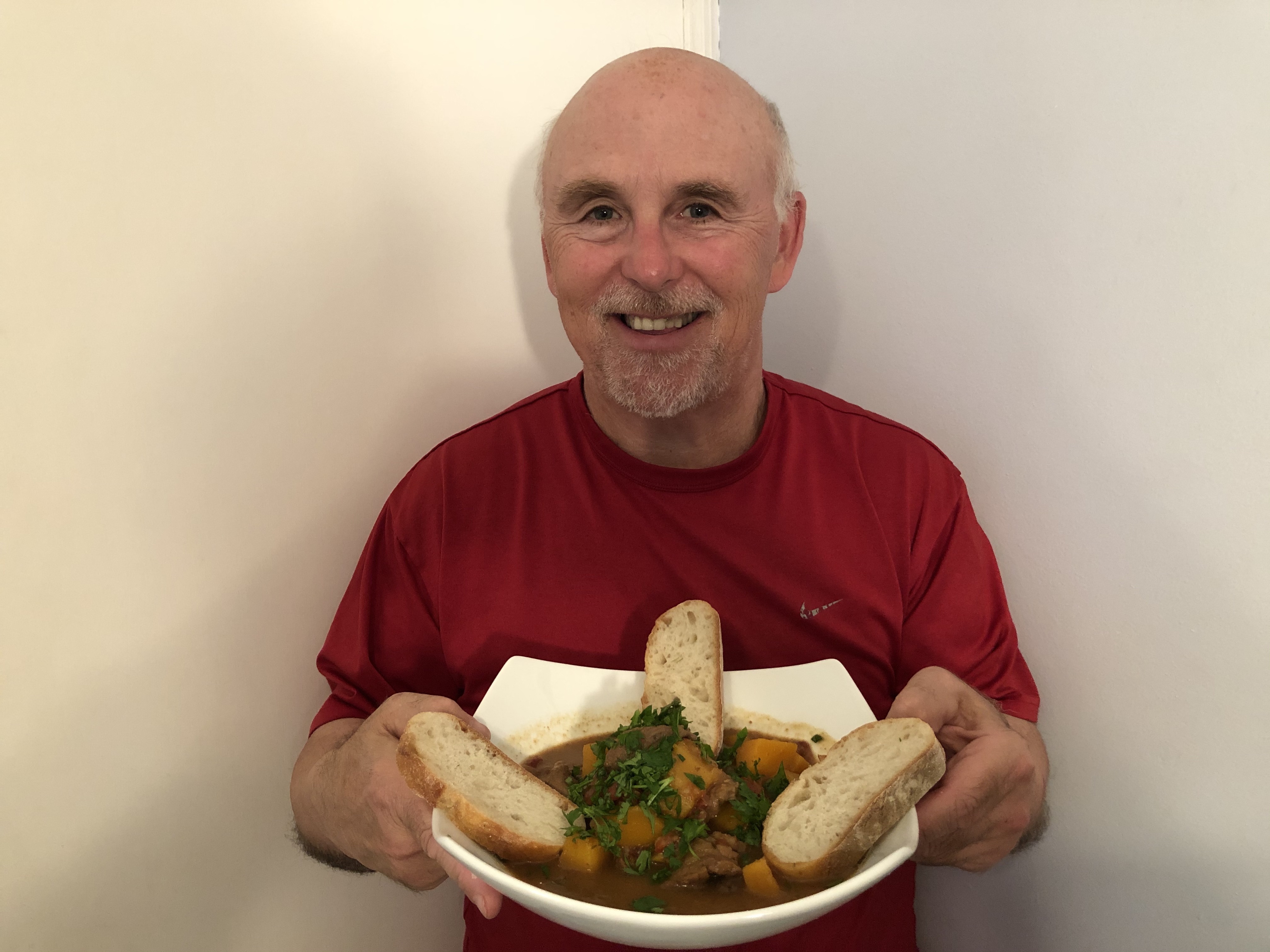 Chef Rob holding a bowl of his beef and butternut squash stew