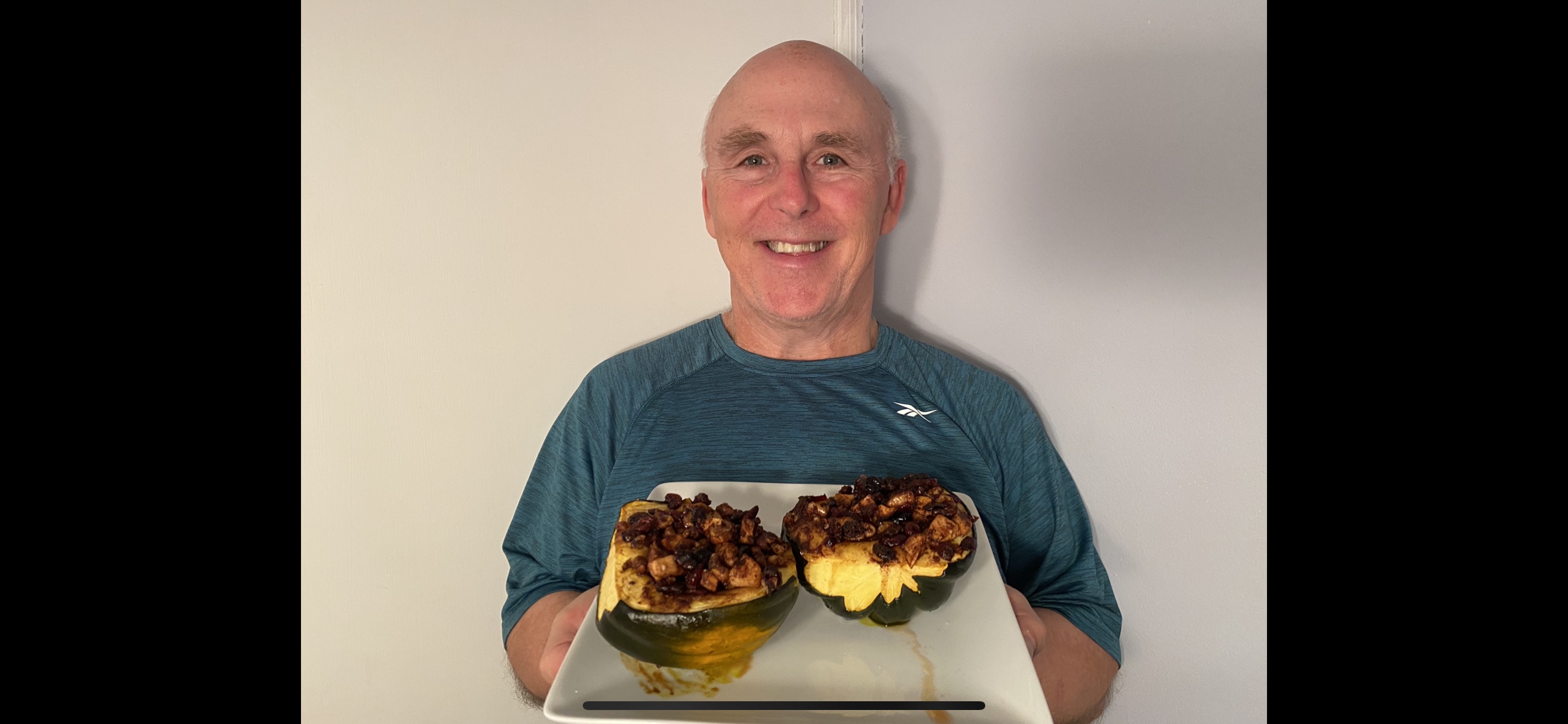 Chef Rob holding a plate of his stuffed acorn squash dish.