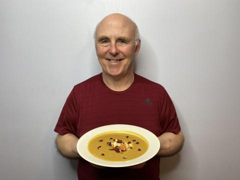 Chef Rob Scott holding a bowl of his pumpkin soup