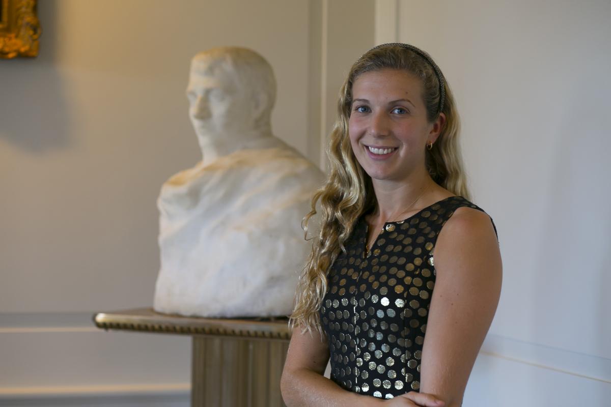 Woman standing beside a marble bust